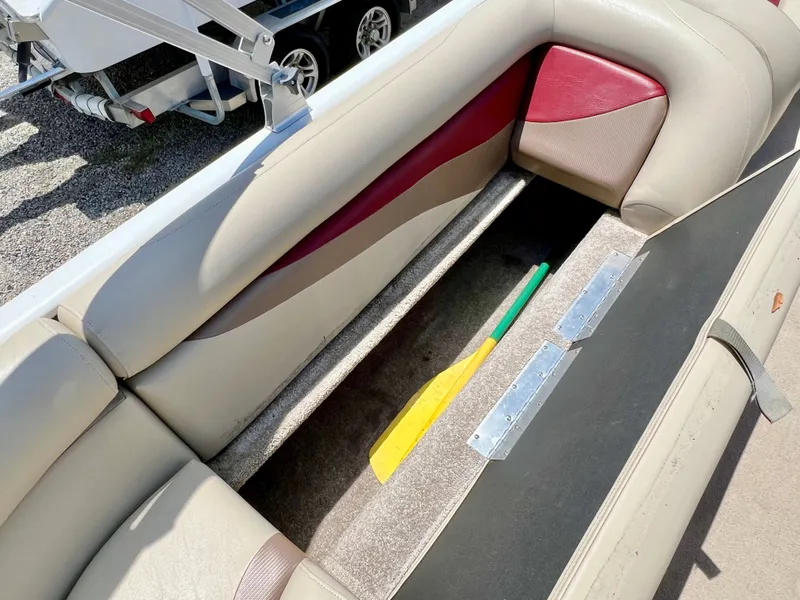 Slide: The Image of The image shows the seating area of a 2016 Lowe Sport Deck 224 with storage underneath. - 23