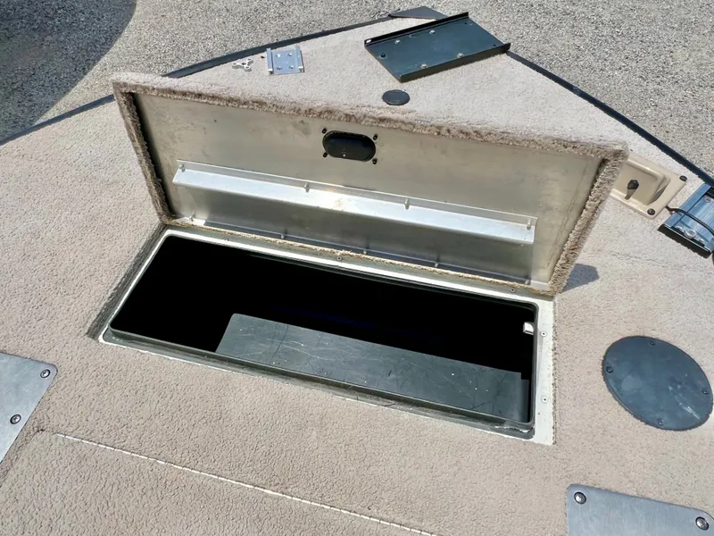 Slide: The Image of An open storage compartment on a boat deck, surrounded by carpeted flooring. - 36