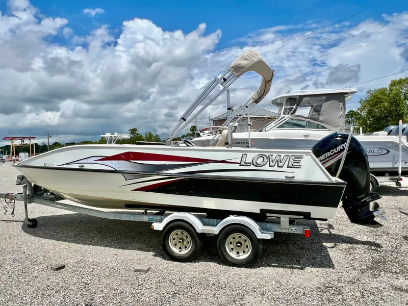 Slide: The Image of A 2016 Lowe Sport Deck 224 boat on a trailer, featuring a Mercury engine and bimini top. - 6