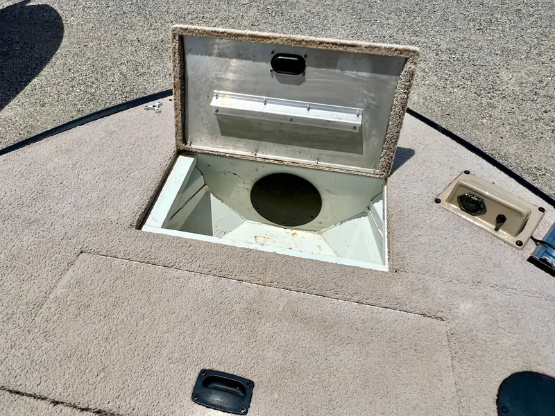 Slide: The Image of An open storage compartment on a carpeted boat deck. - 33
