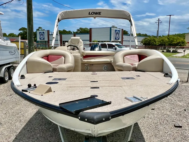 Slide: The Image of The image shows a 2016 Lowe Sport Deck 224 boat with an open deck and beige seating. - 24