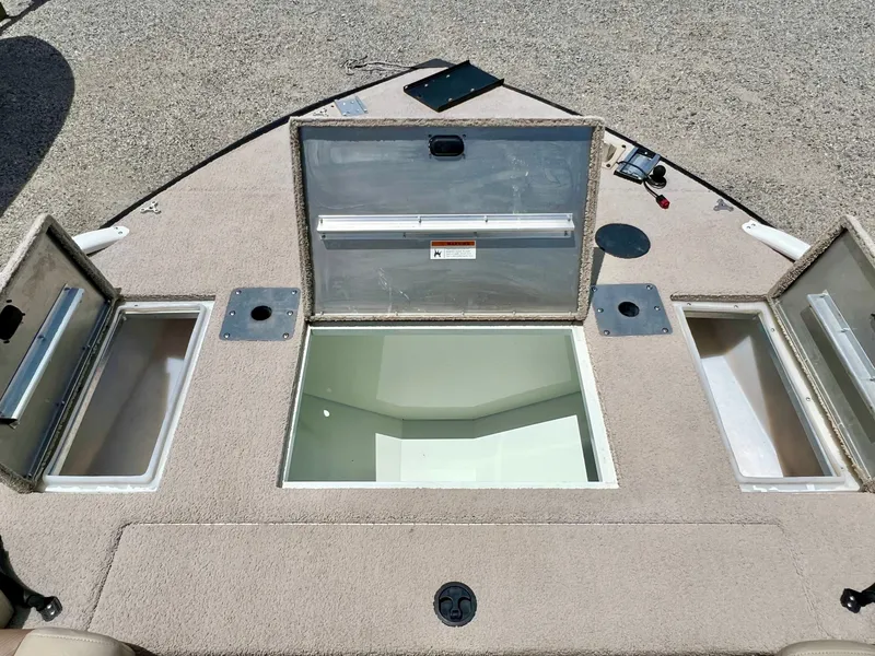 Slide: The Image of The image shows the deck of a 2016 Lowe Sport Deck 224 boat with multiple storage compartments. - 34