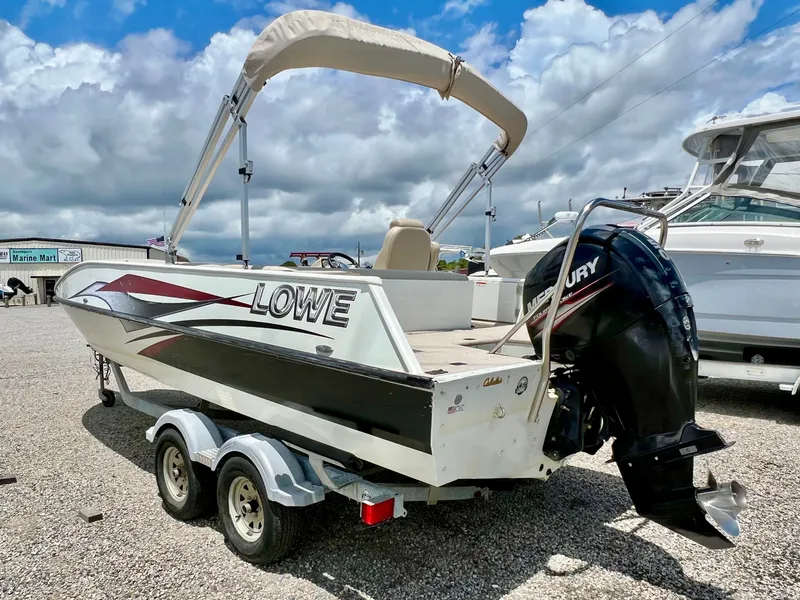 Slide: The Image of A 2016 Lowe Sport Deck 224 boat on a trailer, featuring a Mercury outboard motor. - 8