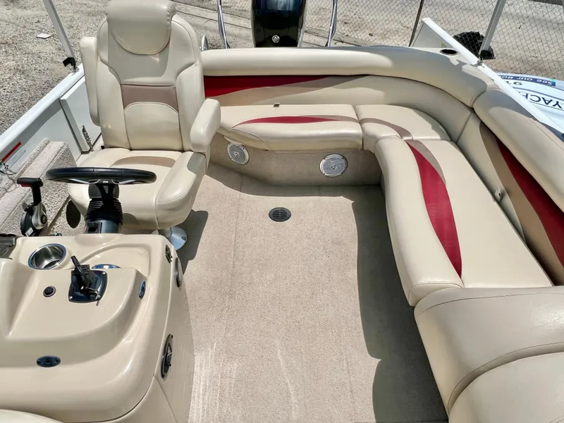 Slide: The Image of The image shows the cockpit of a 2016 Lowe Sport Deck 224 with beige and red seating. - 18