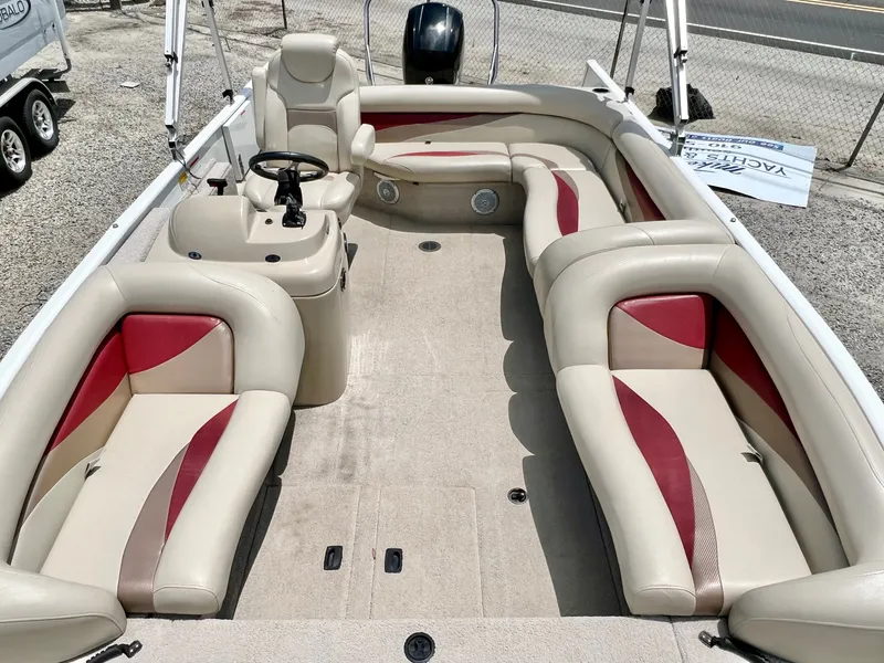 Slide: The Image of The image shows the interior of a 2016 Lowe Sport Deck 224 boat with beige and red seating. - 26