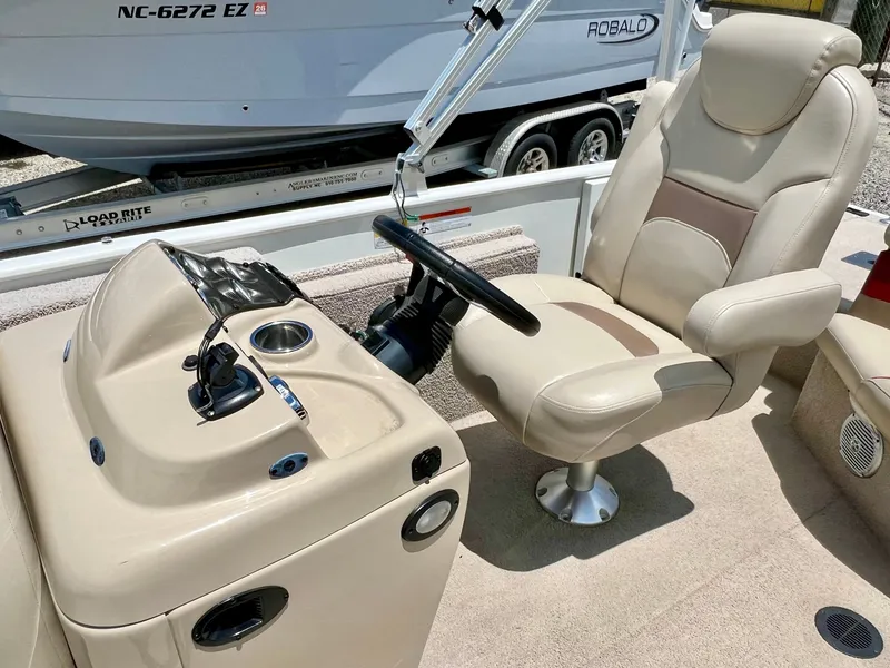 Slide: The Image of The image shows the helm of a 2016 Lowe Sport Deck 224 with a beige seat and steering wheel. - 37