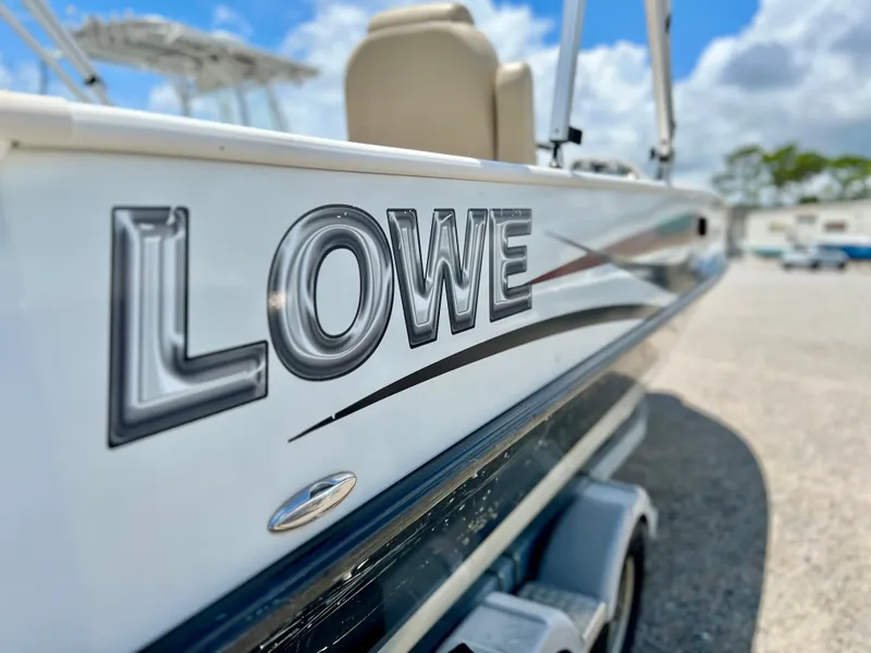 Slide: The Image of A 2016 Lowe Sport Deck 224 boat on a trailer under a blue sky. - 46