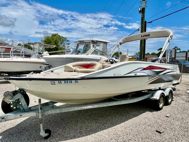 Slide: The Image of A white 2016 Lowe Sport Deck 224 boat sits on a trailer in an outdoor lot. - 5