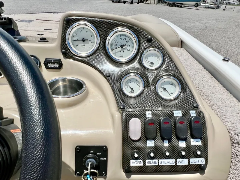 Slide: The Image of The image shows the dashboard of a 2016 Lowe Sport Deck 224 boat with various gauges and switches. - 41