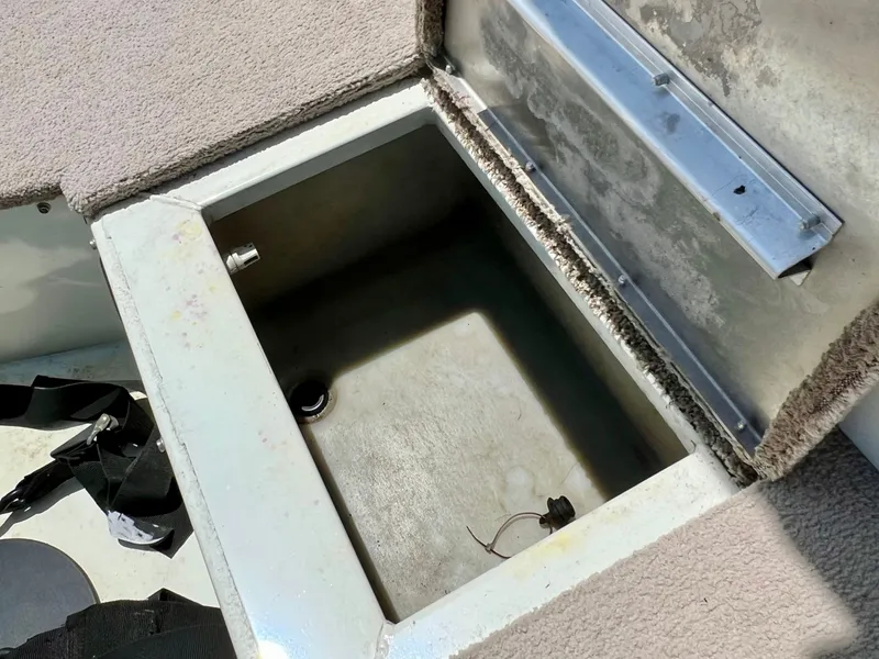Slide: The Image of An open storage compartment on a boat with carpeted flooring and metal framing. - 17