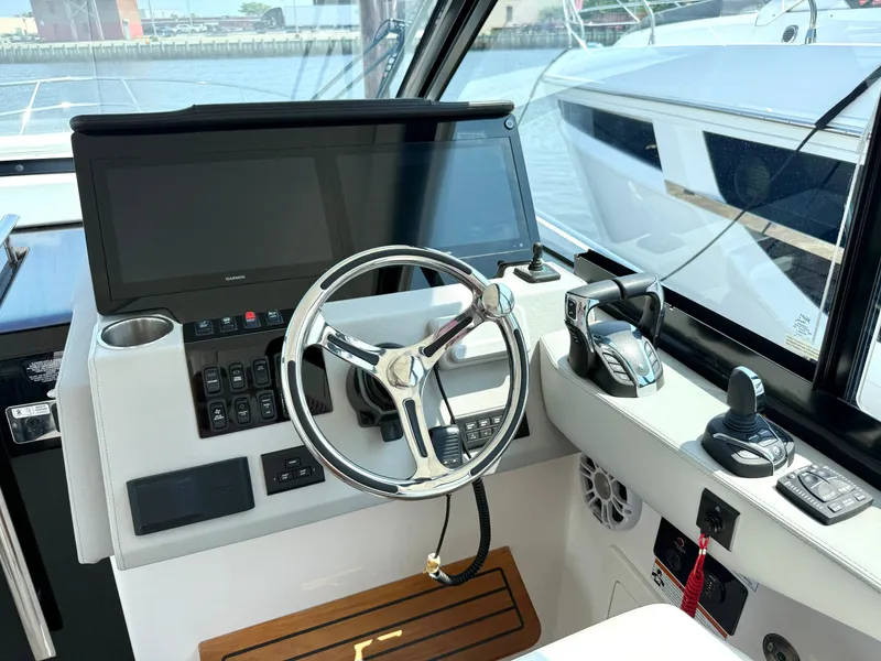 Slide: The Image of The cockpit of the 2023 Regal 36 XO features a modern helm with large screens and controls. - 27