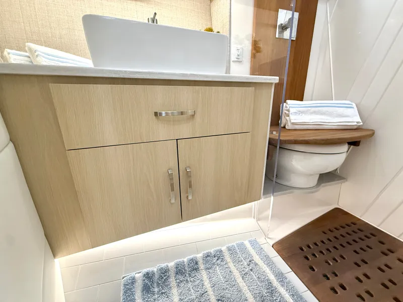Slide: The Image of The image shows a modern boat bathroom with wooden cabinets and a toilet. - 37