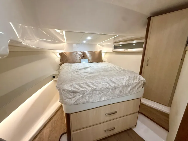 Slide: The Image of The 2023 Regal 36 XO cabin features a cozy bed with drawers underneath and wood paneling. - 31