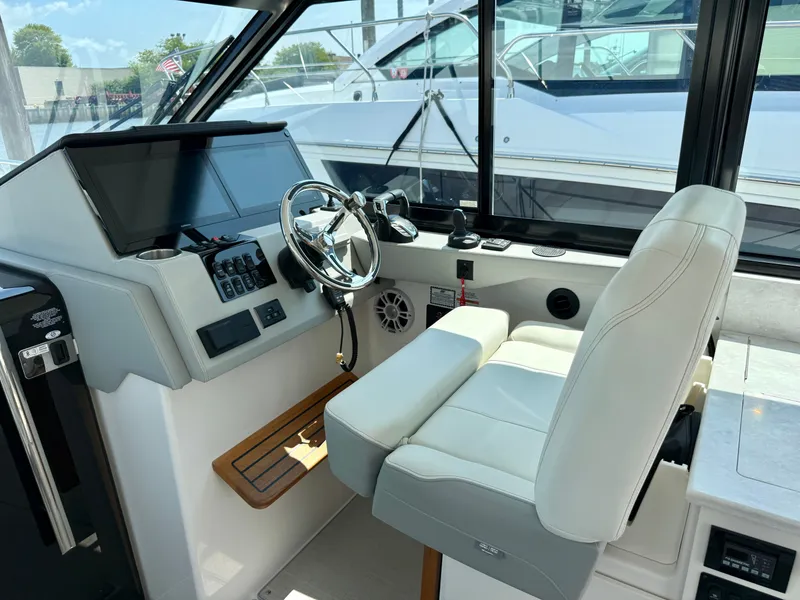 Slide: The Image of The cockpit of the 2023 Regal 36 XO features a modern helm with a leather seat. - 25