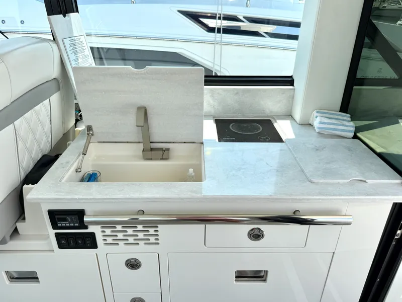 Slide: The Image of The 2023 Regal 36 XO features a sleek kitchenette with a sink and stove. - 23