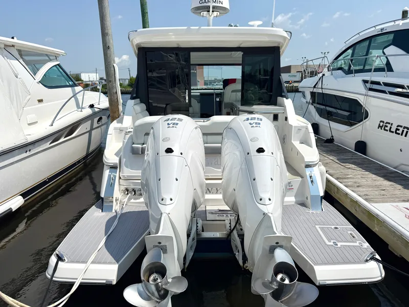 Slide: The Image of The image shows a modern boat with twin outboard engines at the stern, docked at a marina. - 5