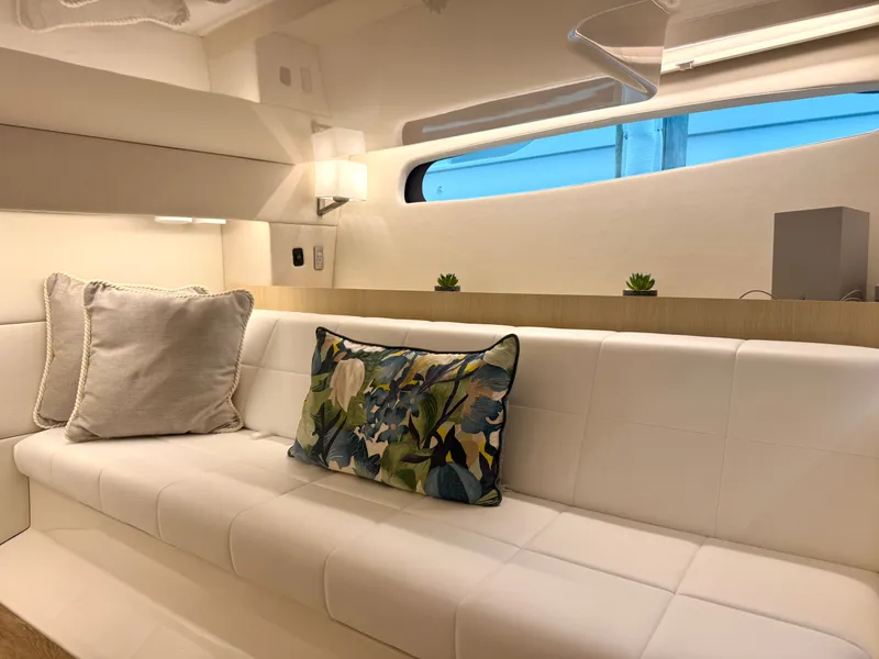 Slide: The Image of Sleek, modern interior with white sofa and decorative pillows in a Regal 36 XO yacht. - 36