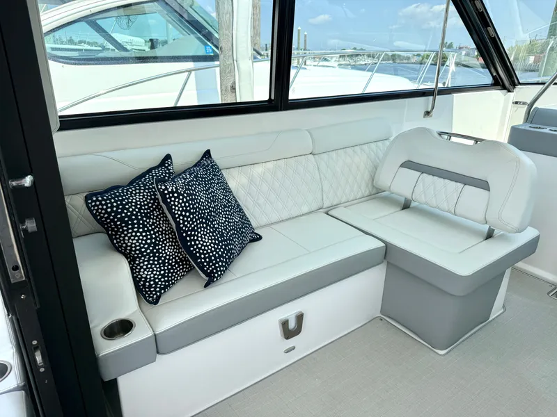 Slide: The Image of The 2023 Regal 36 XO features an elegant seating area with white upholstery and decorative pillows. - 20