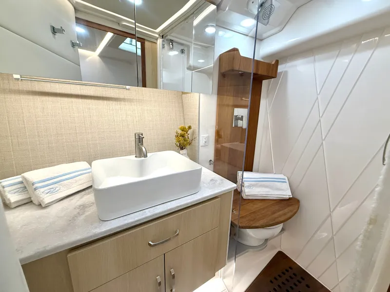 Slide: The Image of The image shows a modern boat bathroom with a sink, toilet, and shower. - 38