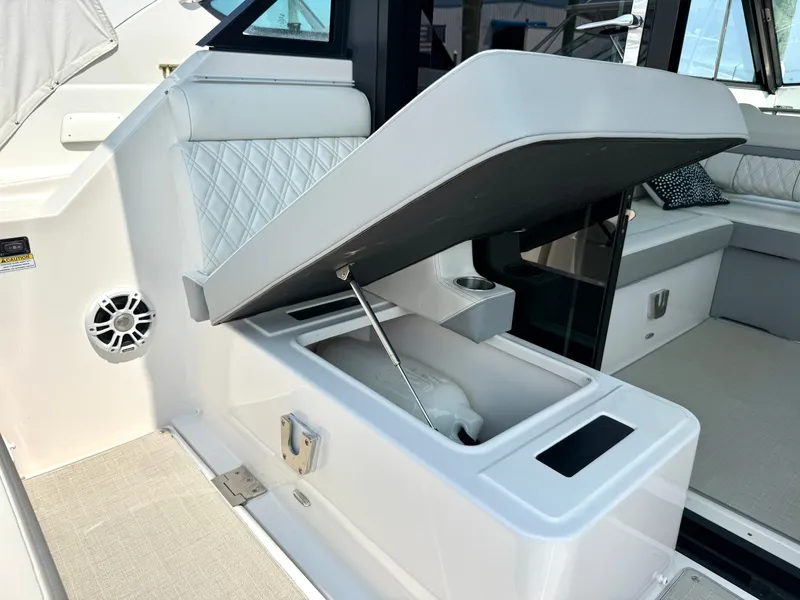 Slide: The Image of The 2023 Regal 36 XO features an open storage compartment with cushioned seating and a speaker. - 13