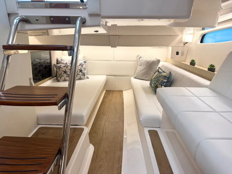 Slide: The Image of The interior of the 2023 Regal 36 XO features an elegant, modern cabin with white upholstery and wood flooring. - 33