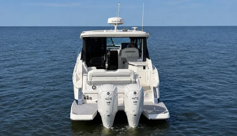 Slide: The Image of A 2023 Regal 36 XO boat with twin outboard engines on calm water. - 4