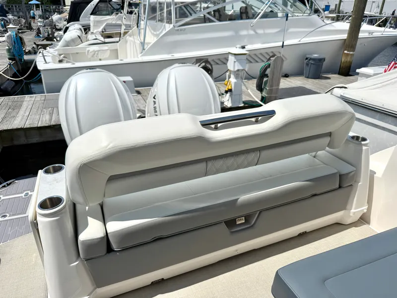 Slide: The Image of The 2023 Regal 36 XO features a luxurious bench seat overlooking the marina. - 9
