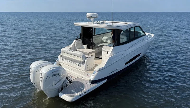 Slide: The Image of A 2023 Regal 36 XO boat on calm water with twin Yamaha outboard engines. - 2