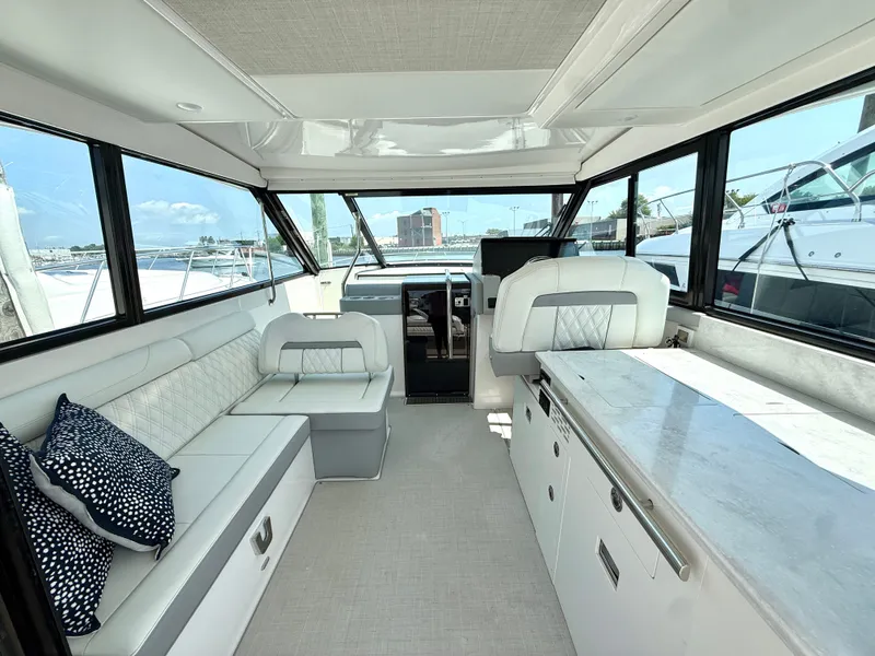Slide: The Image of The image shows the interior of a 2023 Regal 36 XO with sleek white seating and large windows. - 17