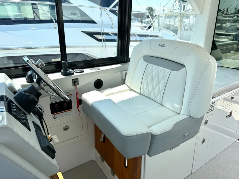 Slide: The Image of The interior of a 2023 Regal 36 XO features a sleek white captain's chair and modern helm. - 26