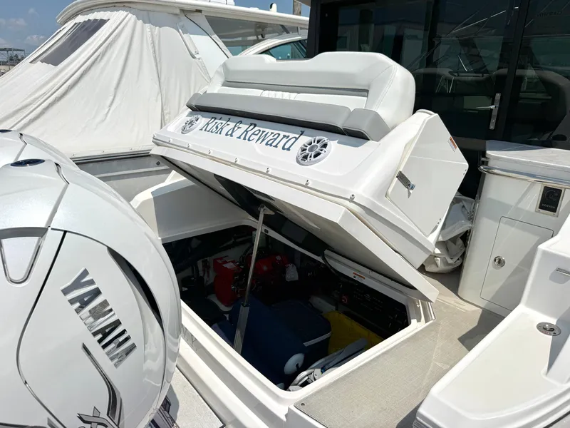Slide: The Image of A 2023 Regal 36 XO boat with an open storage hatch and Yamaha engine. - 48