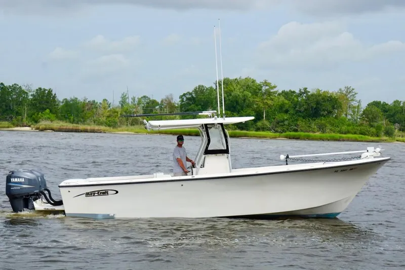 Slide: The Image of 2009 May-Craft 2700CCX boat cruising on a river with lush green shoreline. - 6