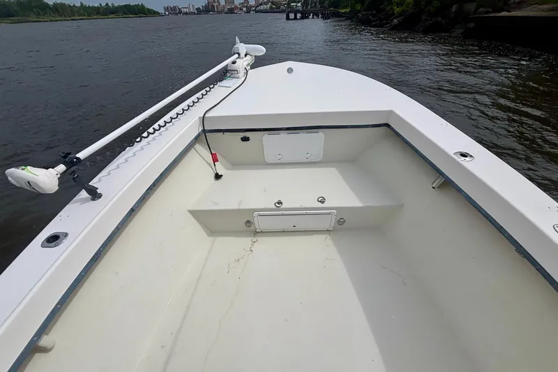 Slide: The Image of 2009 May-Craft 2700CCX boat on calm river, featuring spacious deck and trolling motor. - 15