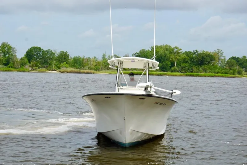 Slide: The Image of 2009 May-Craft 2700CCX boat cruising on a scenic river with lush green shoreline. - 5