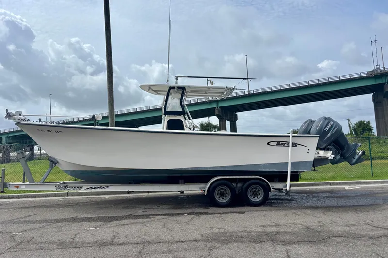 Slide: The Image of 2009 May-Craft 2700CCX boat on trailer, parked near a bridge under cloudy skies. - 7