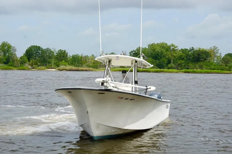 Slide: The Image of 2009 May-Craft 2700CCX boat cruising on a river with lush green shoreline. - 4