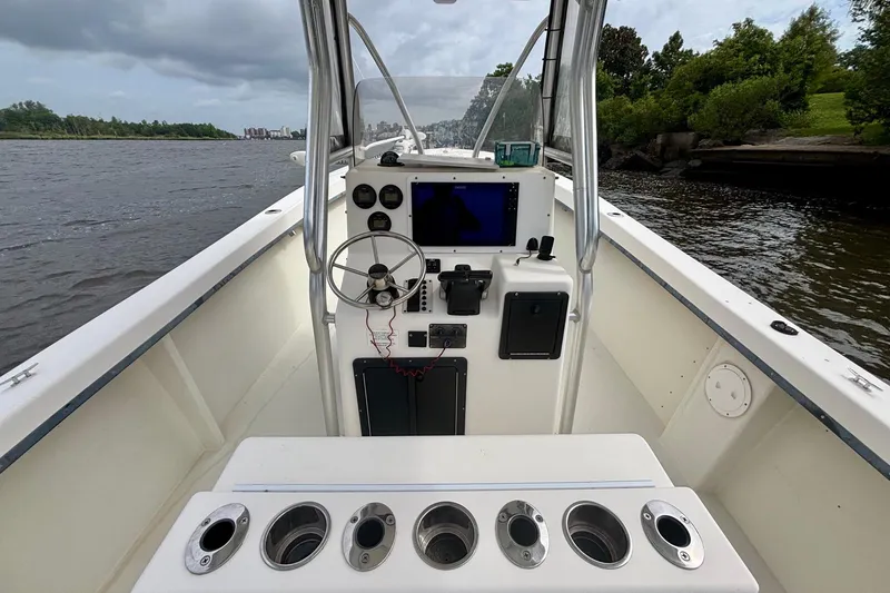 Slide: The Image of 2009 May-Craft 2700CCX boat interior with steering console on a calm river. - 9