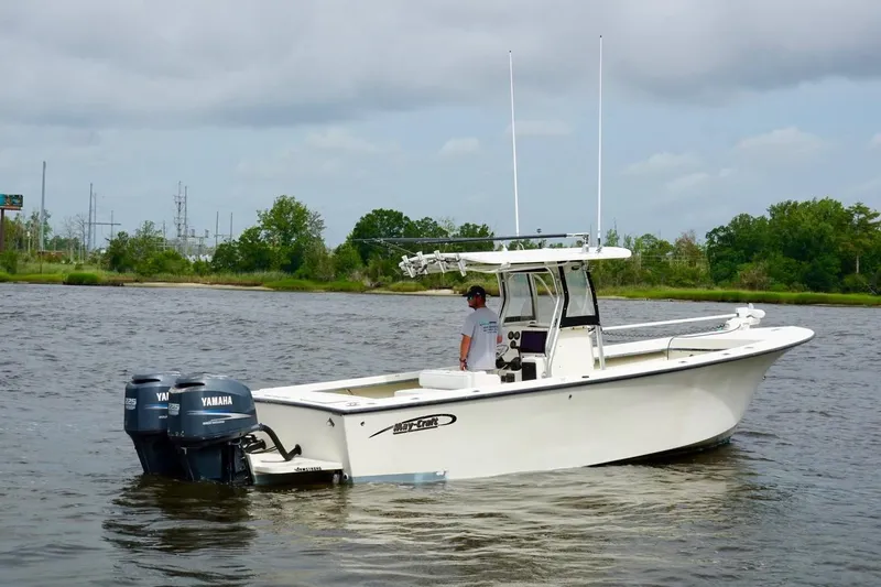 Slide: The Image of 2009 May-Craft 2700CCX boat with dual Yamaha engines on a calm river. - 2