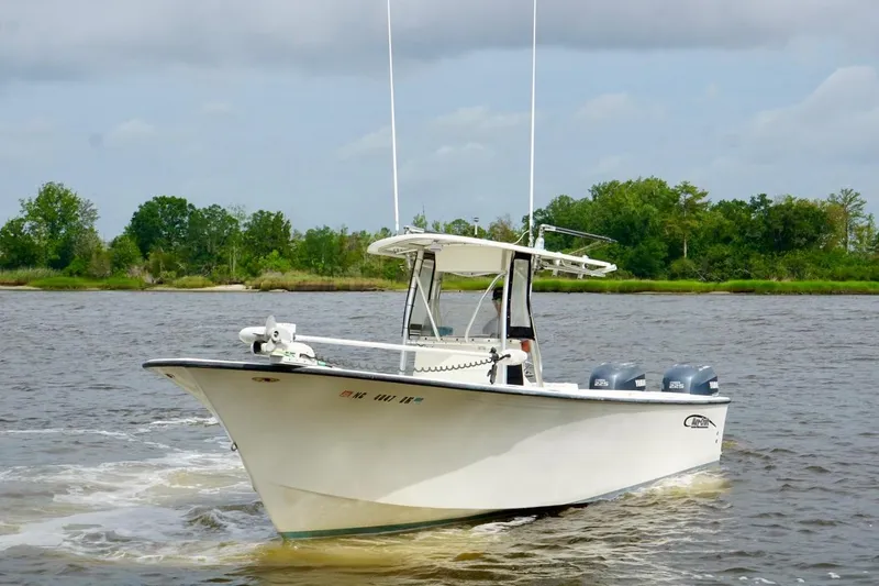 Slide: The Image of 2009 May-Craft 2700CCX boat cruising on a river with lush green shoreline. - 3