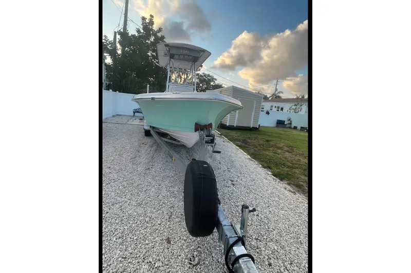 Slide: The Image of 2020 Blue Wave 2600 PureBay boat on trailer, parked on gravel driveway. - 4