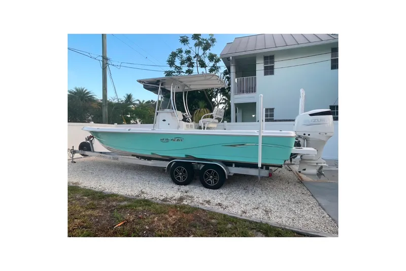The Image of 2020 Blue Wave 2600 PureBay boat on trailer, parked near a house. - 0