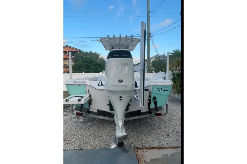 Slide: The Image of 2020 Blue Wave 2600 PureBay boat with powerful outboard motor, parked on gravel. - 3