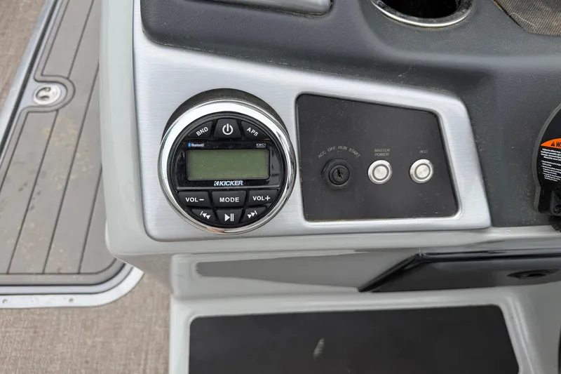 Slide: The Image of Control panel of 2021 Ranger Reata 223FC boat featuring audio system and power switches. - 14
