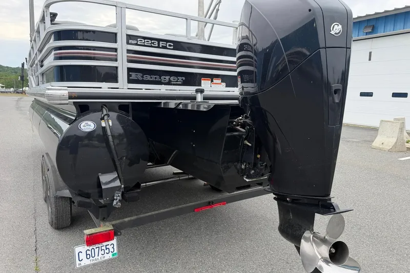 Slide: The Image of 2021 Ranger Reata 223FC boat with powerful outboard motor, parked on a trailer. - 4