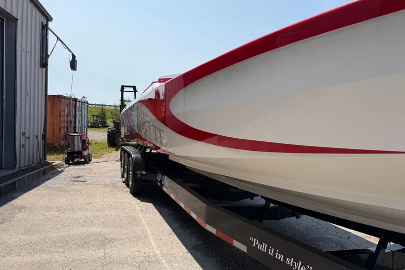 Slide: The Image of 2003 Cigarette 36' Gladiator boat on trailer, red and white design, parked outdoors. - 8