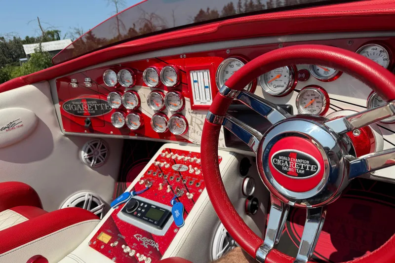 Slide: The Image of 2003 Cigarette 36' Gladiator boat dashboard with red accents and multiple gauges. - 35