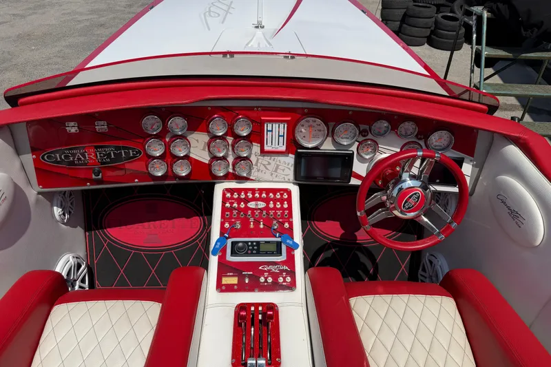 Slide: The Image of Cockpit of 2003 Cigarette 36' Gladiator boat with red and white interior, gauges, and steering wheel. - 33