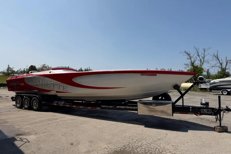 Slide: The Image of 2003 Cigarette 36' Gladiator speedboat on trailer, parked outdoors under clear sky. - 6