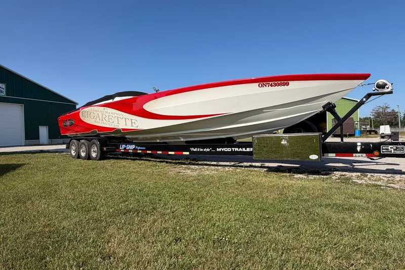 Slide: The Image of 2003 Cigarette 36' Gladiator speedboat on trailer, red and white design, parked outdoors. - 46