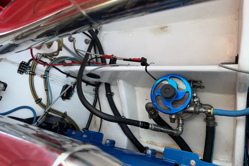 Slide: The Image of Engine compartment of a 2003 Cigarette 36' Gladiator boat, featuring wiring and blue valve. - 43